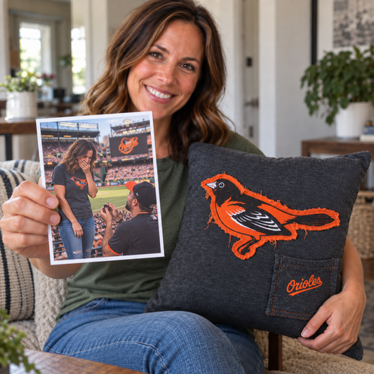 Woman holding a photo of her baseball game proposal and a memory pillow made from the Orioles T-shirt she wore that day.